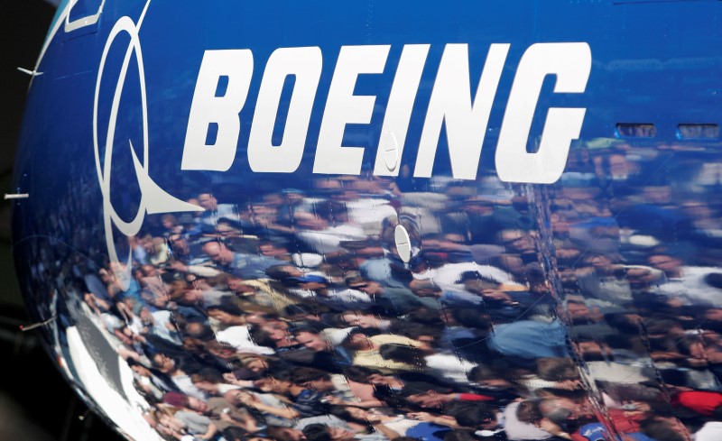 © Reuters. Люди отражаются в фюзеляже самолета Boeing 787 Dreamliner на заводе Boeing в Эверетте, США