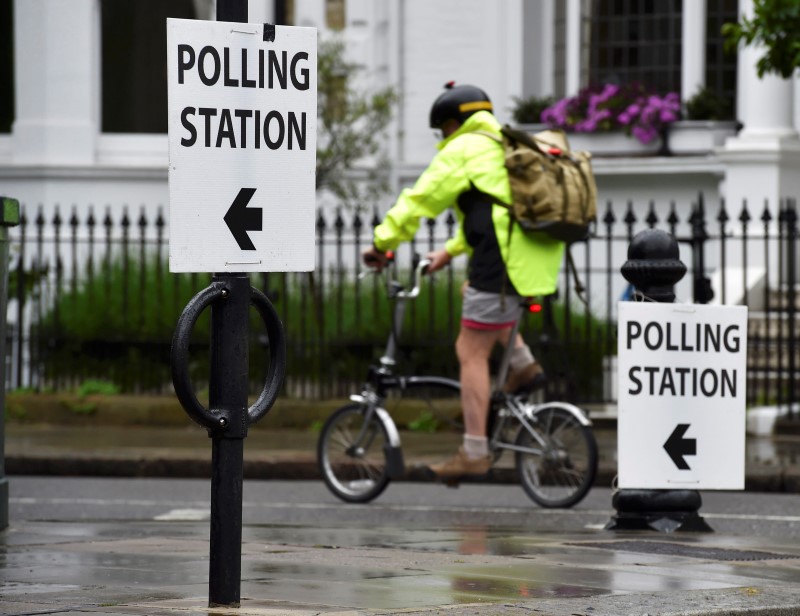 © Reuters. A man cycles past a polling station for the Referendum on the European Union in west London