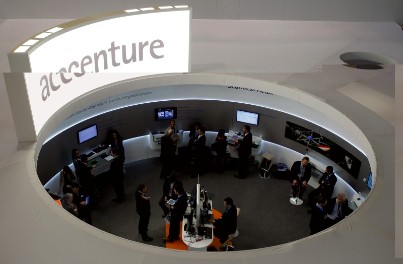 © Reuters. Visitors look at devices at Accenture stand at the Mobile World Congress in Barcelona