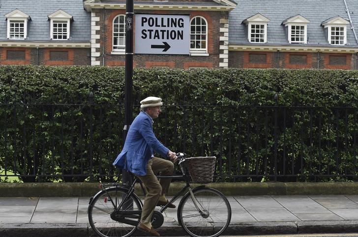 © Reuters. Homem passa de bicicleta por local de votação do referendo britânico