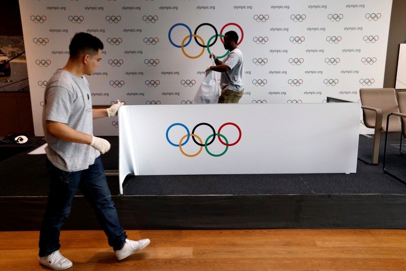 © Reuters. Staff of the IOC dismantle a backdrop after a news conference after the Olympic Summit on doping in Lausanne