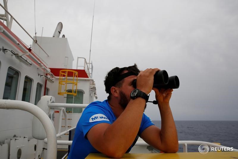 © Reuters. A crew member on the Migrant Offshore Aid Station (MOAS) ship Topaz Responder keeps a look out for migrants in distress in international waters off the coast of Libya