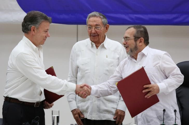 © Reuters. Juan Manuel Santos cumprimenta líder das Farc Londoño após acordo em Havana