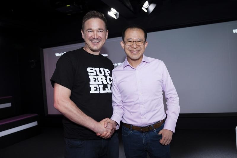 © Reuters. Finnish game company Supercell Co-Founder and CEO Ilkka Paananen and Martin Lau, President of Tencent, pose while meeting with the press in the company's headquarters in Helsinki