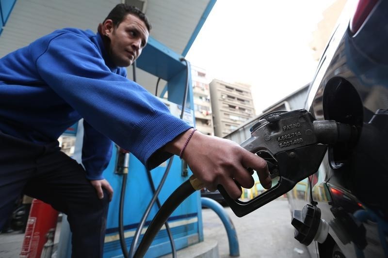 © Reuters. An employee holds a fuel pump nozzle as he fills up a car with fuel at a CO-OP gas station in Cairo