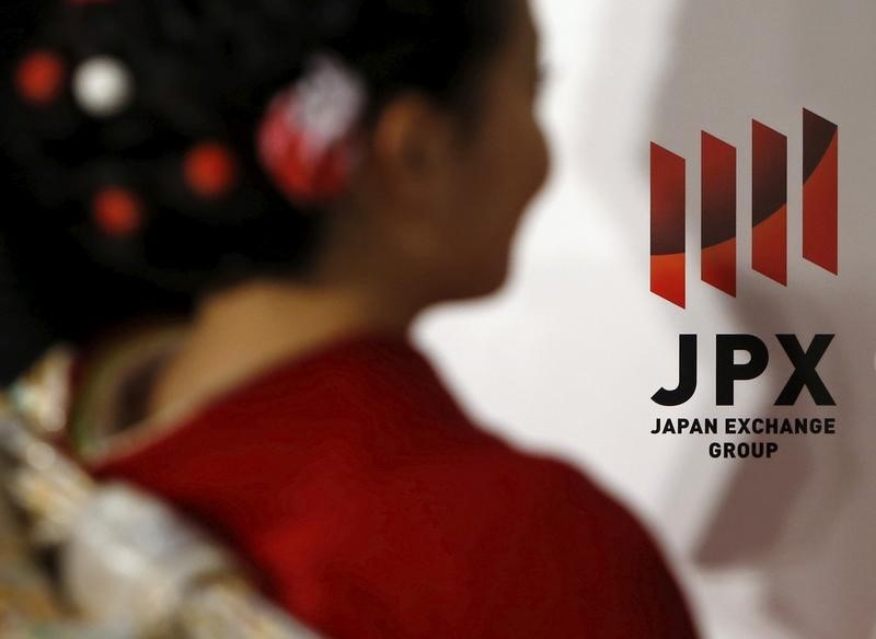 © Reuters. A logo of Japan Exchange Group Inc. is seen next to a woman before the New Year opening ceremony at the Tokyo Stock Exchange