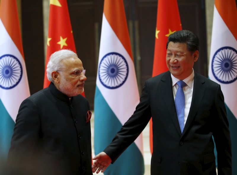 © Reuters. Chinese President Xi Jinping guides Indian Prime Minister Narendra Modi to a meeting room in Xian