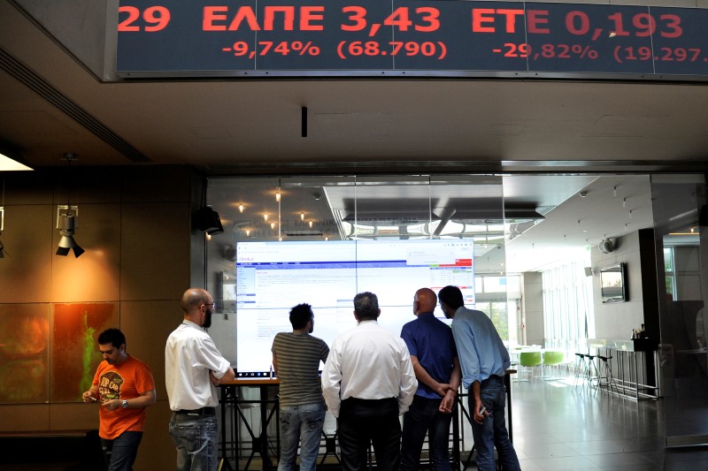 © Reuters. Employees stand in front of electronic board showing stock options inside the Athens stock exchange building in Athens