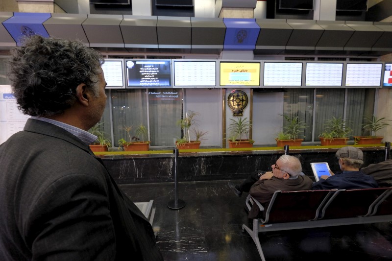 © Reuters. Iranian shareholders look at electronic display boards in Tehran's Stock Exchange