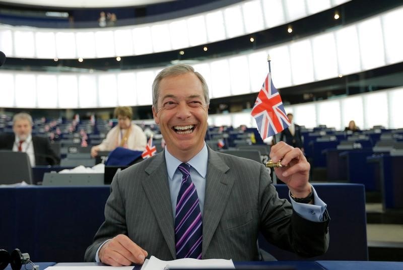 © Reuters. Farage, leader of the UKIP and MEP holds a British Union Jack flag as he waits for the start of a debate at the European Parliament in Strasbourg