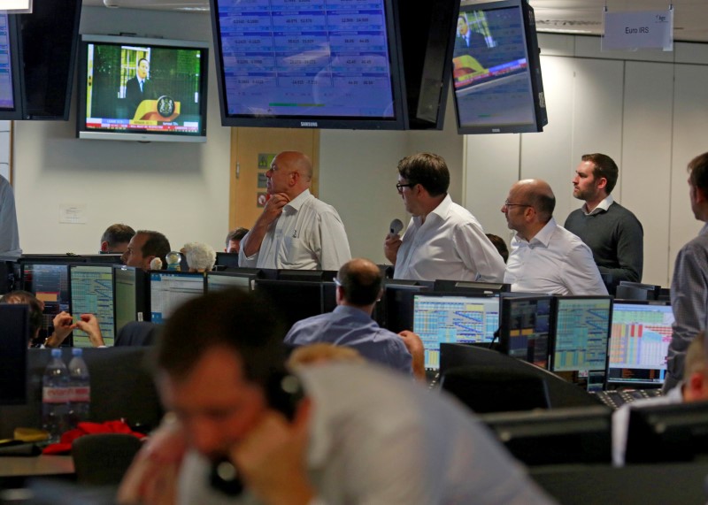 © Reuters. A TV shows the resignation of Britain's Prime Minister David Cameron as traders from BGC, a global brokerage company in London's Canary Wharf financial centre react after European stock markets opened