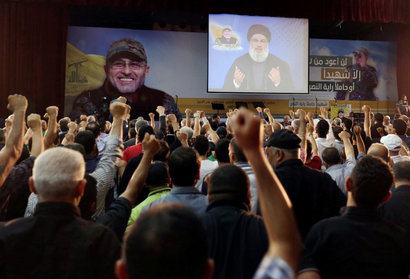 © Reuters. Supporters of Lebanon's Hezbollah leader Sayyed Hassan Nasrallah react as he addresses them from a screen during a ceremony marking the 40th day after Hezbollah commander Mustafa Badreddine was killed in an attack in Syria, in Beirut's southern suburbs