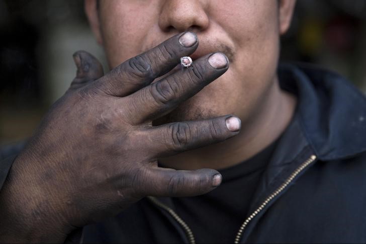 © Reuters. Worker smokes a cigarette in the Willets Point area of Queens in New York