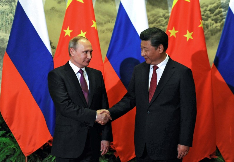 © Reuters. Chinese President Xi shakes hands with Russian counterpart Putin during welcoming ceremony in Beijing,