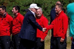 © Reuters. Republican presidential candidate Donald Trump shakes hands with his workers after he landed on the golf course at his Trump International Golf Links in Aberdeen