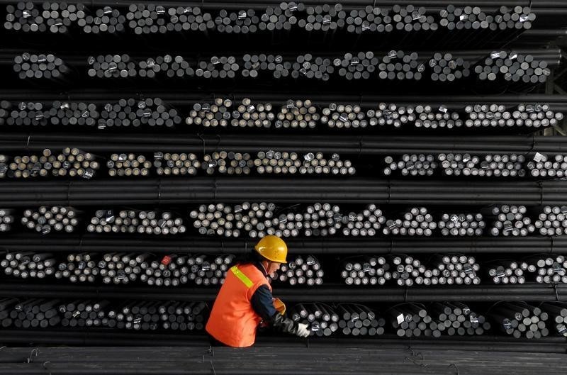 © Reuters. A labourer marks steel bars at a steel and iron factory in Huai'an