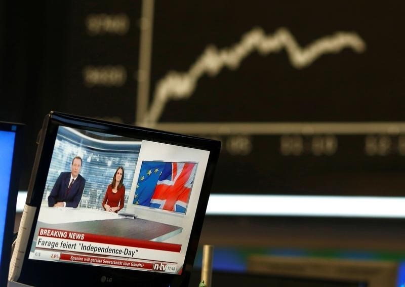 © Reuters. A news broadcast on a TV is pictured in front of the German share price index DAX board, at the stock exchange in Frankfurt