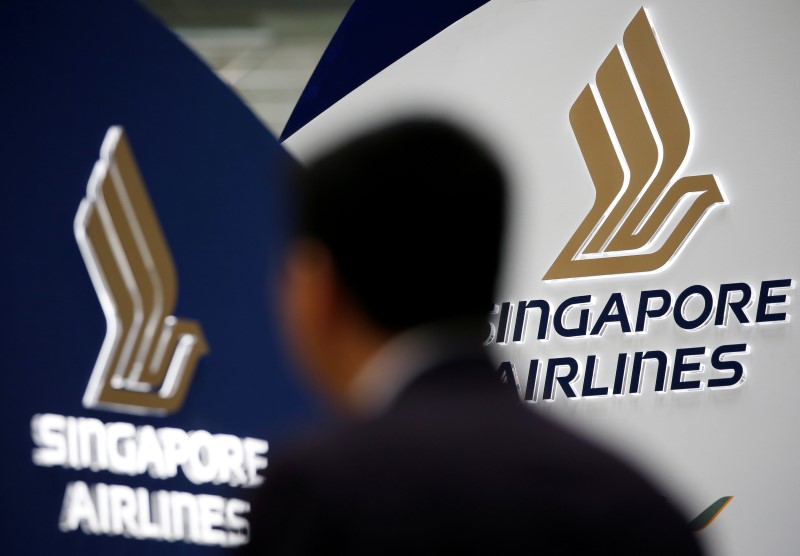 © Reuters. A man walks past a Singapore Airlines signage at Changi Airport in Singapore