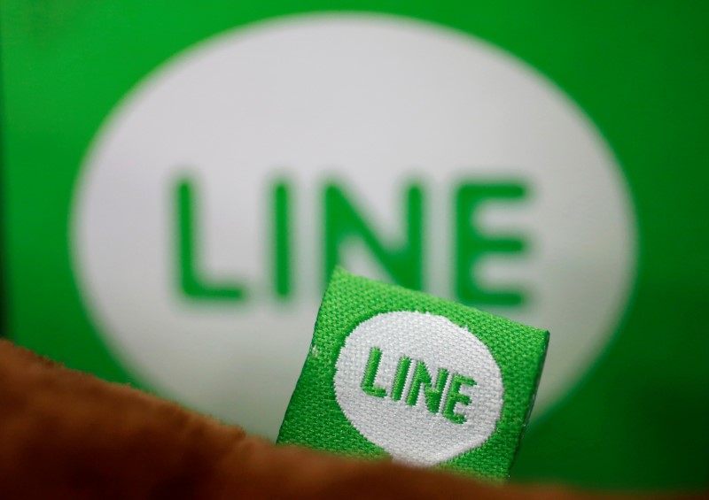 © Reuters. The logo of free messaging app Line is pictured on a smartphone and the company's stuffed toy in this photo illustration taken in Tokyo