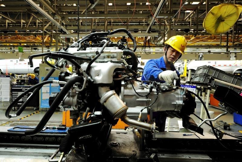 © Reuters. Рабочий на конвейере автомобильной фабрики в Циндао, Китай