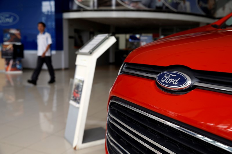 © Reuters. A worker walks near a Ford Ecosport at the Central Jakarta Ford Dealer in Jakarta