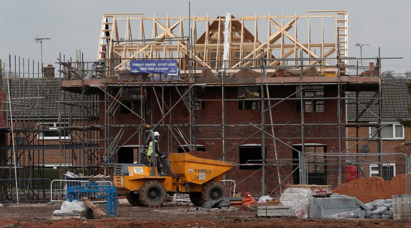 © Reuters. A worker drives a dumper truck past a house being built on a construction site in Chester