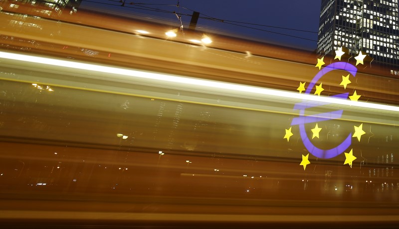 © Reuters. The famous euro sign landmark is seen through the lights of a passing tram outside the former headquarters of the European Central Bank in Frankfurt, Germany