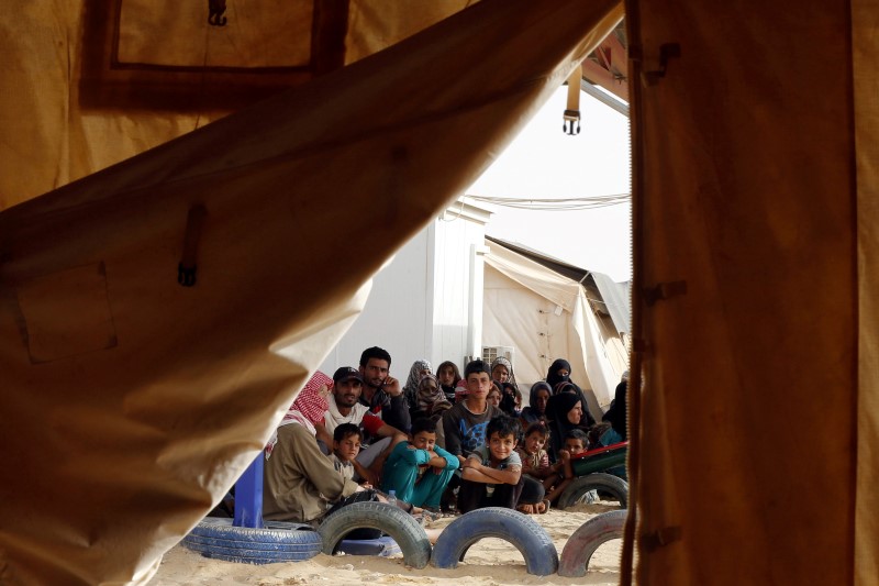 © Reuters. Syrian refugees wait to board a Jordanian army vehicle after crossing into Jordanian territory