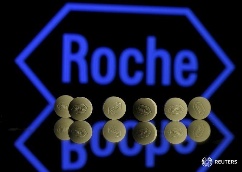 © Reuters. Roche tablets are seen positioned in front of a displayed Roche logo in this photo illustration