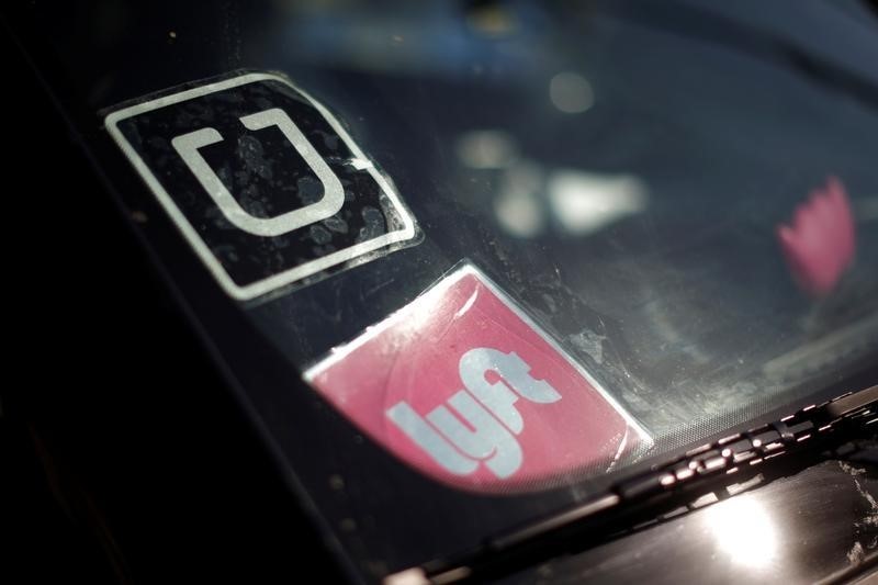 © Reuters. File photo of a  driver displaying Uber and Lyft ride sharing signs on his car windscreen in Santa Monica