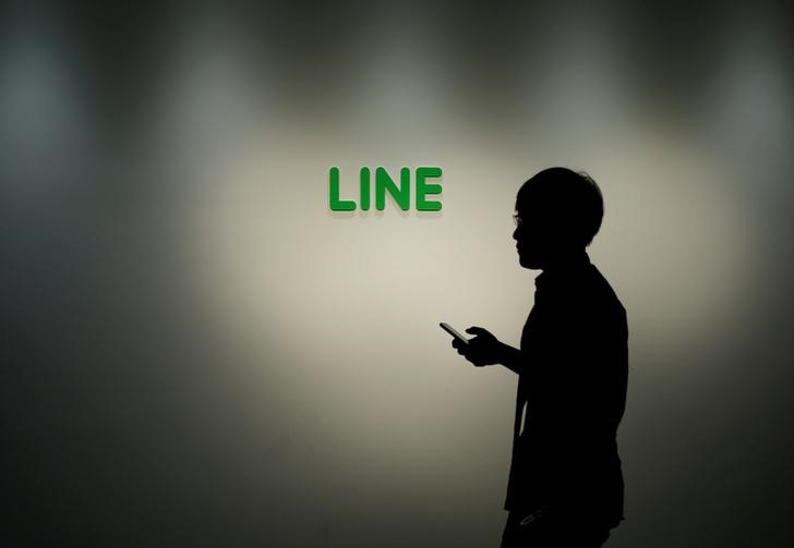© Reuters. Man walks past the logo of Line Corp at the company's headquarters in Tokyo