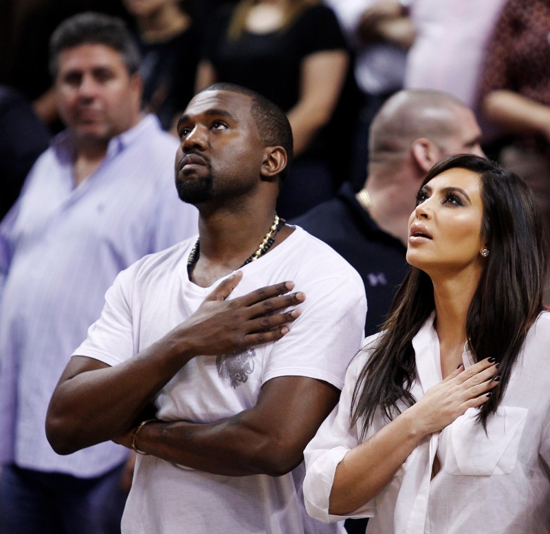 © Reuters. Rapper Kanye West e a mulher, a estrela de reality show Kim Kardashian, durante jogo de basquete em Miami