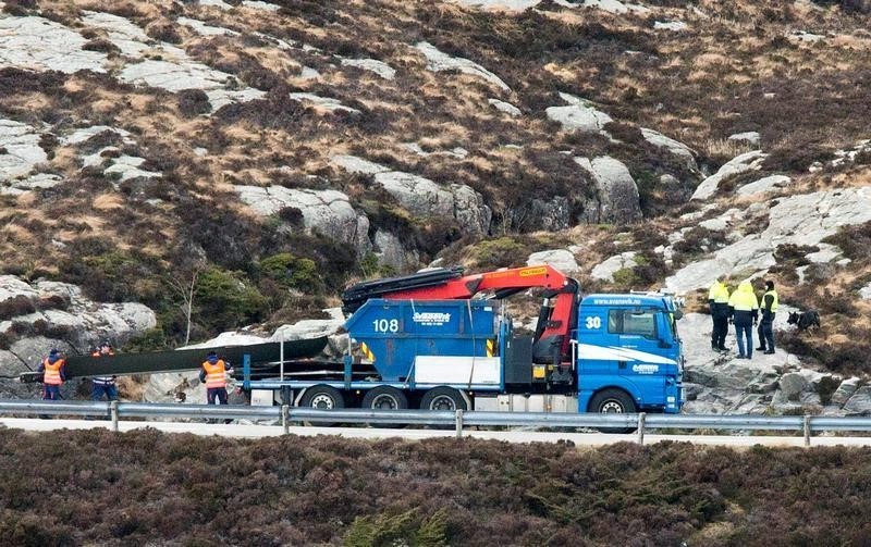 © Reuters. Helicopter rotorblades are brought away from Turoy outside Bergen, where a helicopter crashed Friday April 29