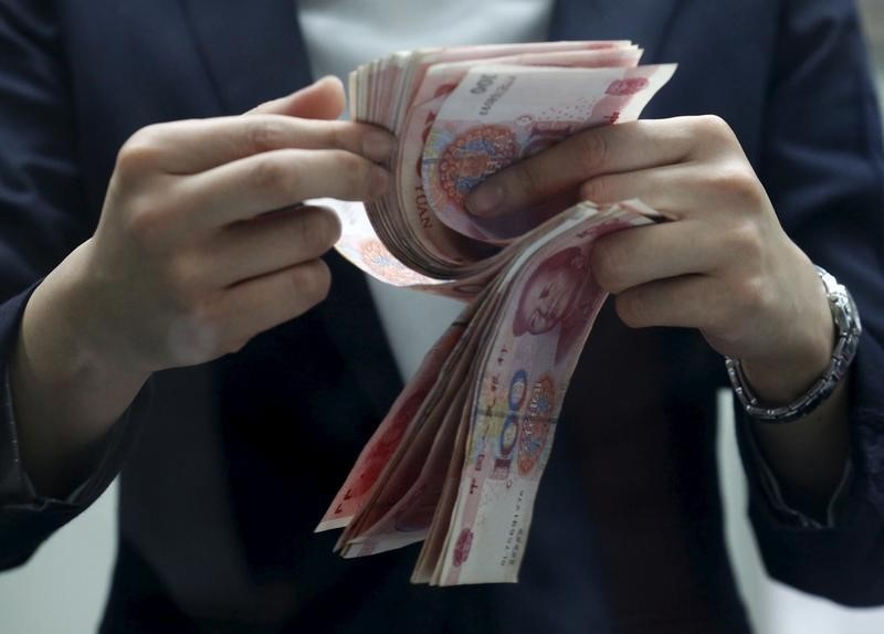 © Reuters. A clerk counts Chinese 100 yuan banknotes at a branch of a foreign bank in Beijing