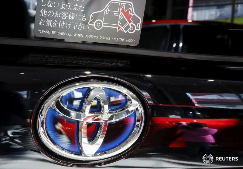 © Reuters. A visitor is reflected on a Toyota Motor Corp's Prius hybrid car at the company's showroom in Tokyo