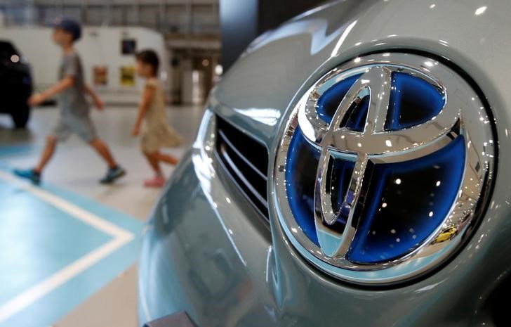 © Reuters. Visitors walk past a logo of Toyota Motor Corp in Tokyo