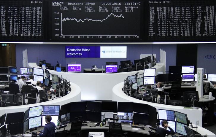 © Reuters. Traders work at their desks in front of the German share price index, DAX board, at the stock exchange in Frankfurt