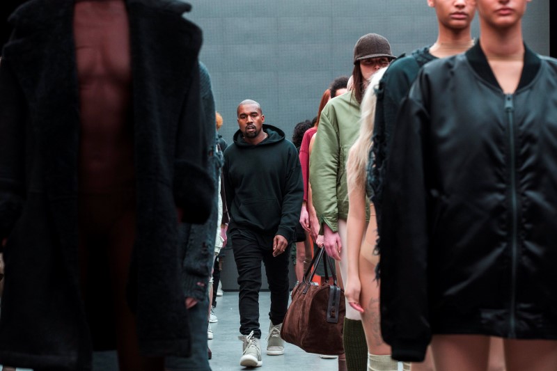 © Reuters. Singer Kanye West walks past models after presenting his Fall/Winter 2015 partnership line with Adidas at New York Fashion Week