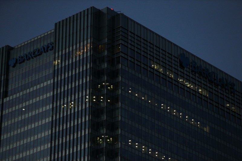 © Reuters. Office lights are on in banks as dawn breaks behind the financial district of Canary Wharf, in London