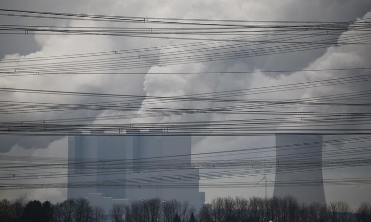 © Reuters. Power lines are pictured in front of the coal power plant of RWE as steam rises from the cooling towers of one of Europe's biggest electricity and gas companies in Neurath