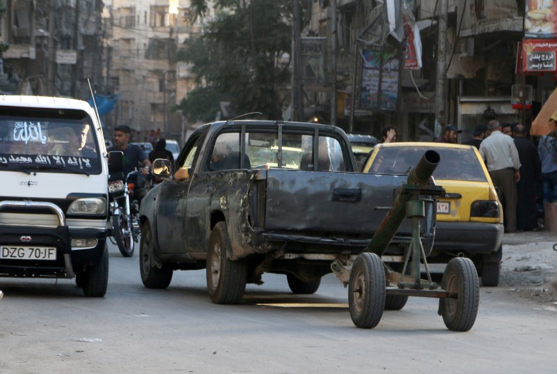 © Reuters. A truck that belongs to Free Syrian Army fighters pulls an improvised mortar launcher along a street in the rebel-held area of Aleppo's al-Shaar district