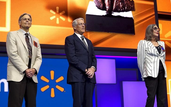 © Reuters. Walton family members Jim, Rob and Alice Walton speak onstage at the Wal-Mart annual meeting in Fayetteville