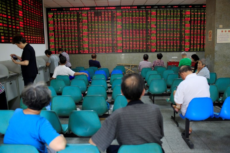 © Reuters. Investors look at an electronic board showing stock information at a brokerage house in Shanghai