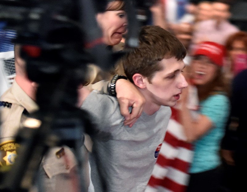 © Reuters. Las Vegas police lead Michael Steven Sandford from Republican U.S. presidential candidate Donald Trump's campaign rally at the Treasure Island Hotel & Casino in Las Vegas