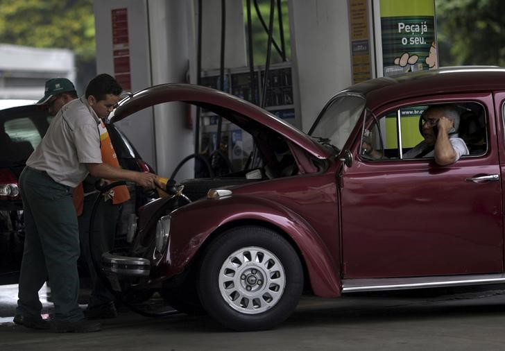 © Reuters. A worker fills a car at a Brazilian Oil Company Petrobras gas station in Rio de Janeiro