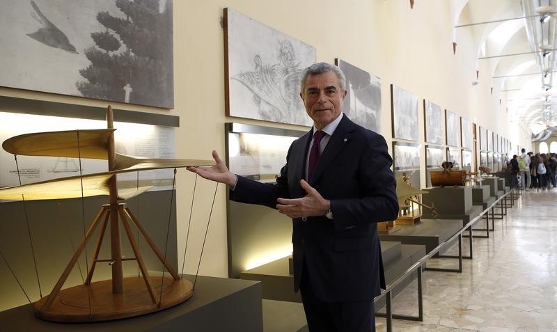 © Reuters. Finmeccanica's CEO Moretti gestures next to Leonardo Da Vinci's project of a flying machine, also known as the "Helical Air Screw", after a news conference about 2015's full-year results in Milan