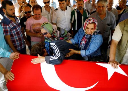 © Reuters. Relatives of a victim of Tuesday's attack on Ataturk airport mourn at her flag-draped coffin during her funeral ceremony in Istanbul