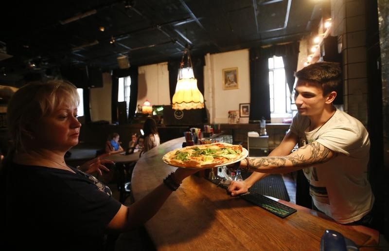 © Reuters. An employee serves pizza at a restaurant in Moscow