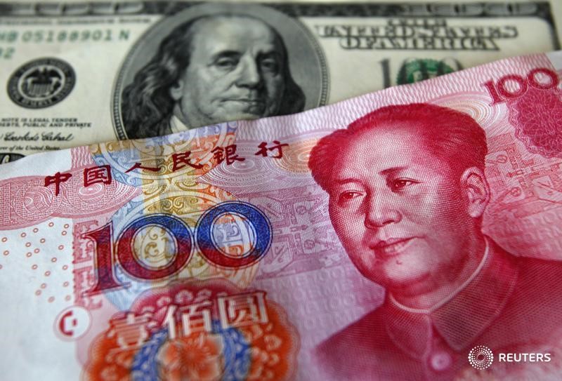 © Reuters. Банкноты в 100 юаней и 100 долларов