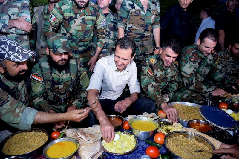 © Reuters. Syria's President Bashar al-Assad joins Syrian army soldiers for Iftar in the farms of Marj al-Sultan village